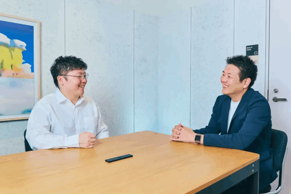 株式会社CLUE様の支援事例のインタビュー写真。テーブルを挟んで担当者2名が話している